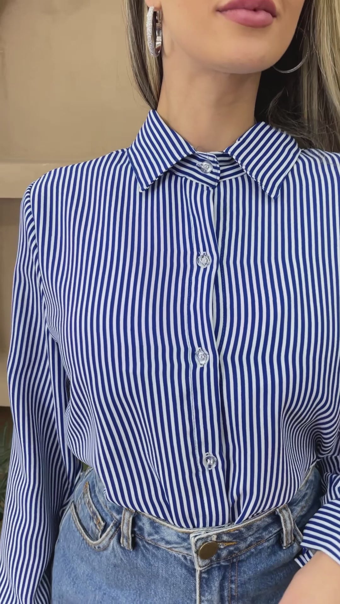 Camisa feminina listrada social duna com gola lapela, fechamento frontal por botões e mangas.